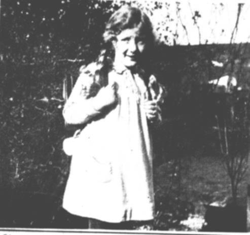 Ohne Schultte, denn die war damals noch nicht blich, wird Elma Schier im Garten fotografiert. Das Schwmmchen fr die Schiefertafel baumelt aus dem Tornister heraus.