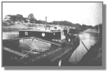 Auch das ist der Schleppkahn "7" der SGDE, aber ohne Steuerhaus. Der Kahn hatte das Erz vom Emder Hafen in Grimberg gelöscht und fuhr nun leer auf dem Rhein-Herne-Kanal zur Zeche, um Kohle zu laden. Da ein unbeladenes Schiff wesentlich höher aus dem Wasser ragt als ein beladenes, mußte das Steuerhaus wegen der vielen Brücken abgebaut werden.